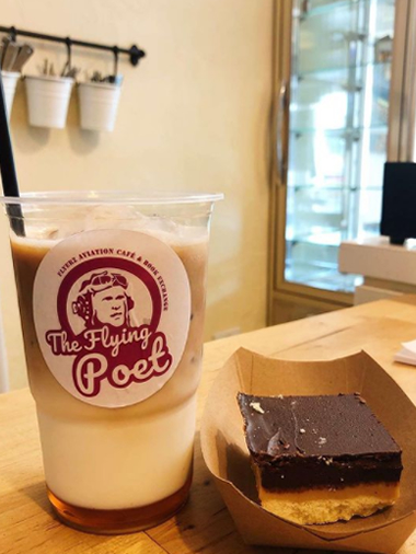 an iced coffee next to a cake